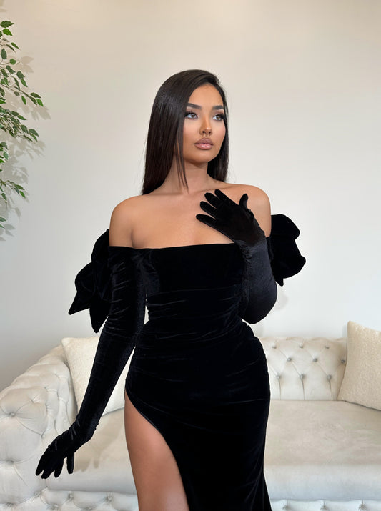 A woman with black hair, black dress and black gloves